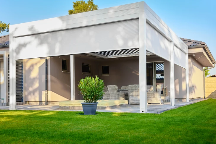 Terrasse extérieure couverte d'une pergola bioclimatique moderne avec lames orientables blanches