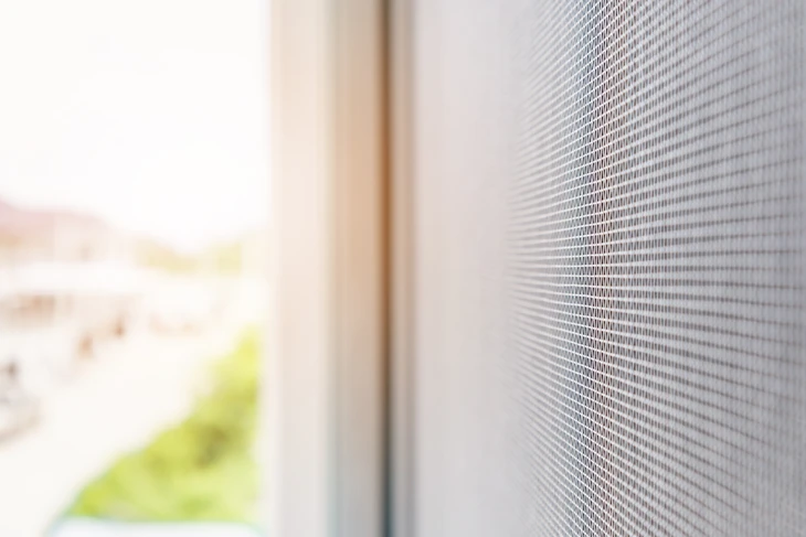 Intérieur résidentiel avec moustiquaire fine installée sur fenêtre