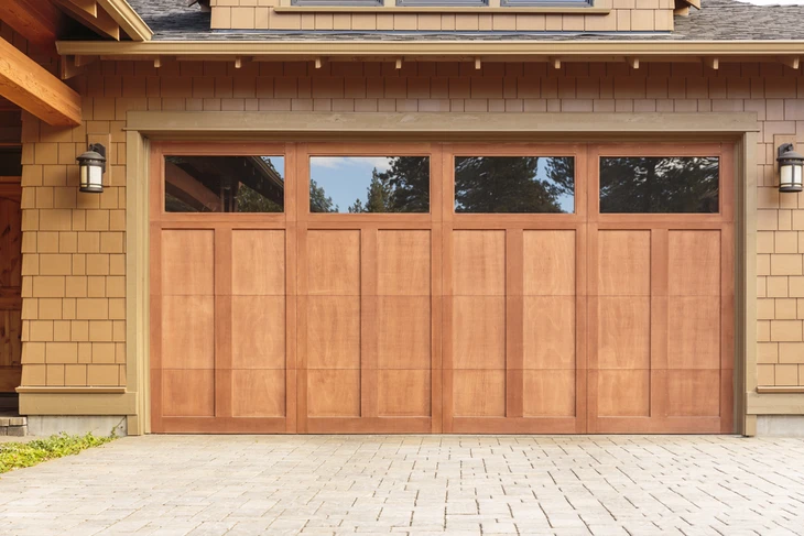 Façade extérieure résidentielle avec porte de garage double en bois naturel