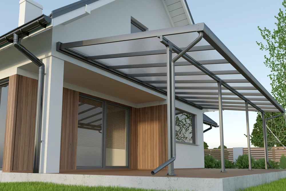 Terrasse extérieure résidentielle moderne avec pergola métallique à structure aluminium gris anthracite et couverture polycarbonate translucide