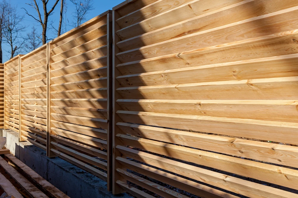Installation d'une clôture horizontale en bois autour de la maison et de la terre